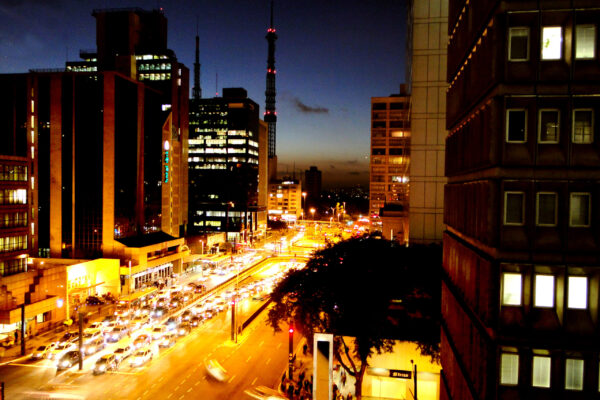 Avenida Paulista in São Paulo at dusk with office towers and traffic lights