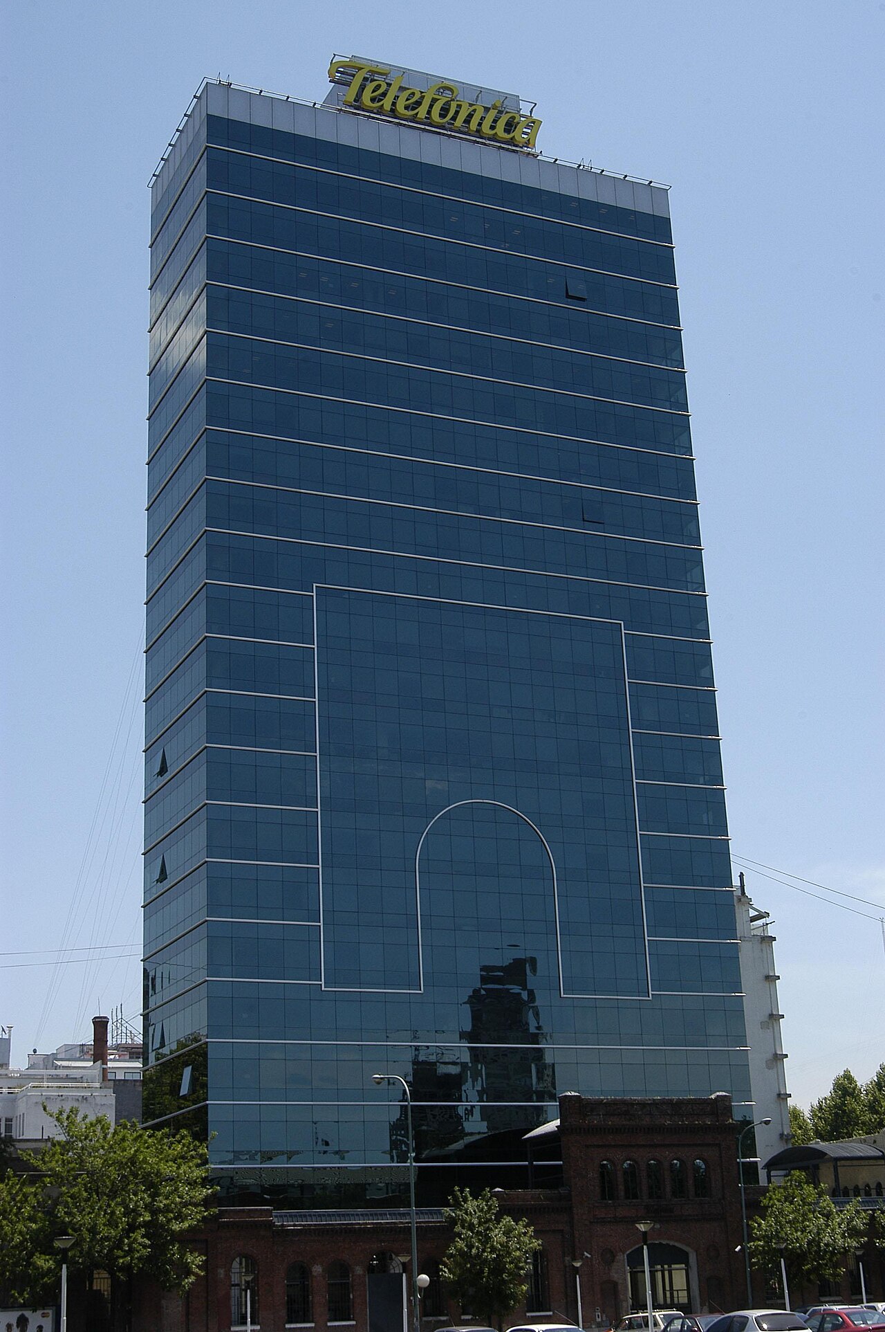 Blue glass office tower with the Telefónica sign on top, above an old brick building in the San Telmo district of Buenos Aires