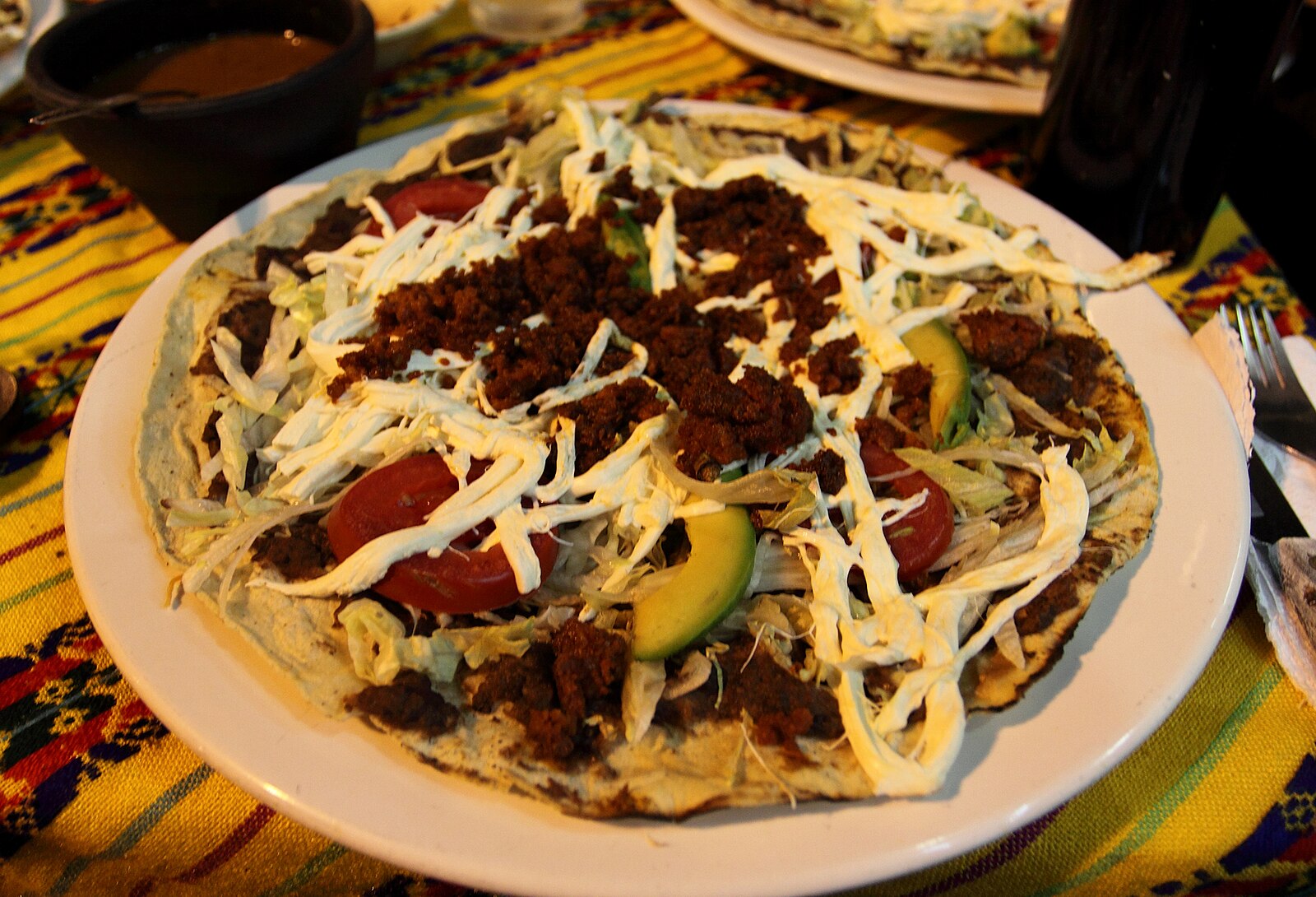 Tlayudas in Oaxaca: a tlayuda with chorizo, quesillo, lettuce, tomato and avocado