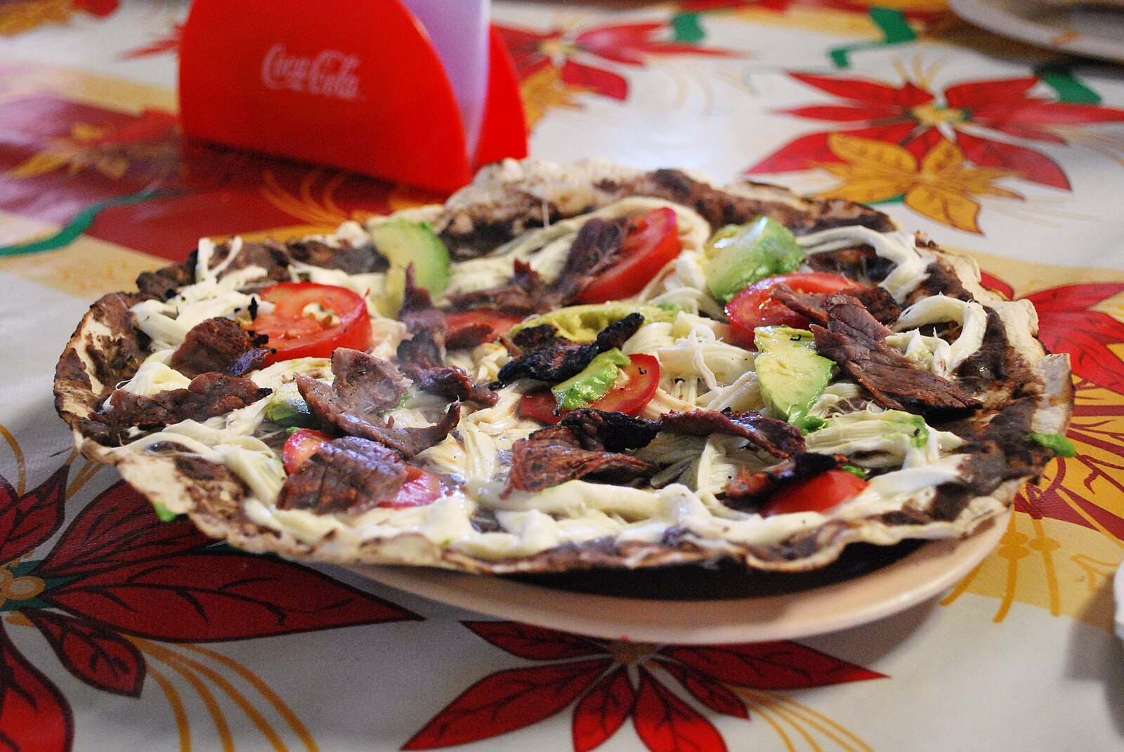 Tlayudas in Oaxaca: an open tlayuda with tasajo at a food stand in Santa María del Tule