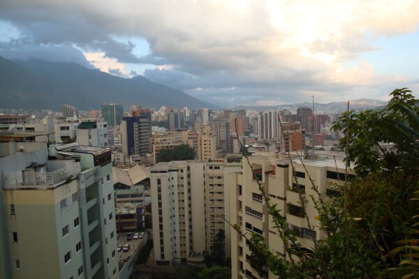 Apartment blocks and office towers of Caracas below the Avila mountain under a cloudy sky