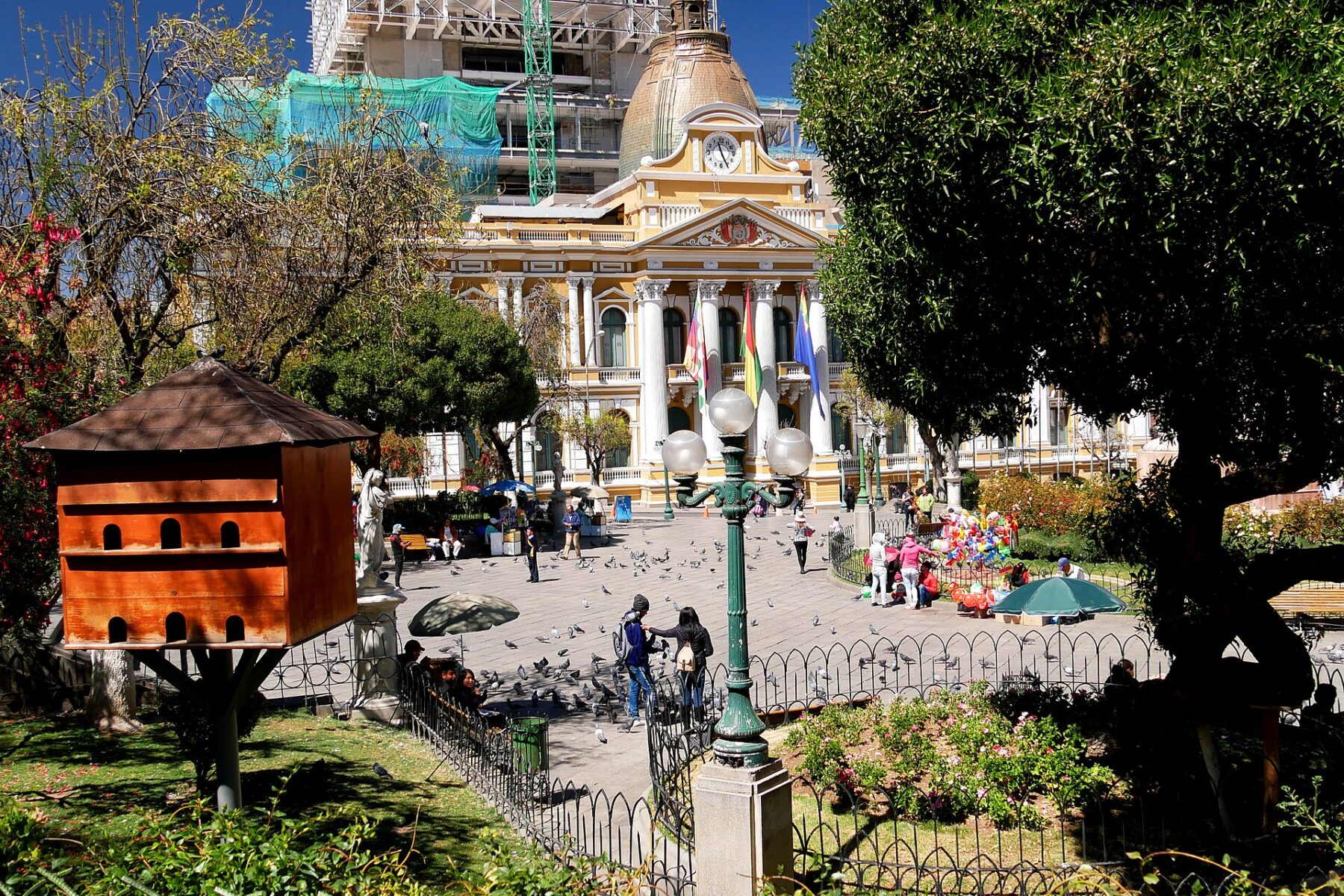 Plaza Murillo in La Paz with a yellow neoclassical government building, pigeons and visitors in the square