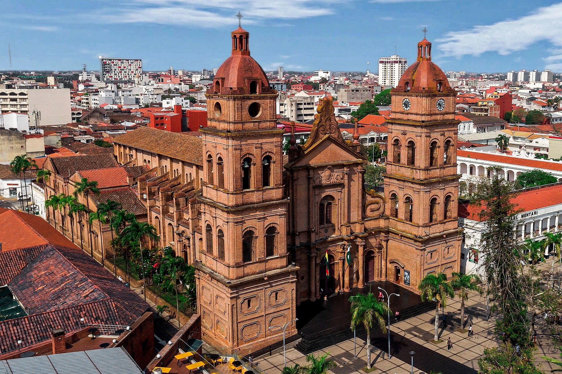 Aerial view of the twin-towered brick cathedral on the main plaza of Santa Cruz de la Sierra with city rooftops behind