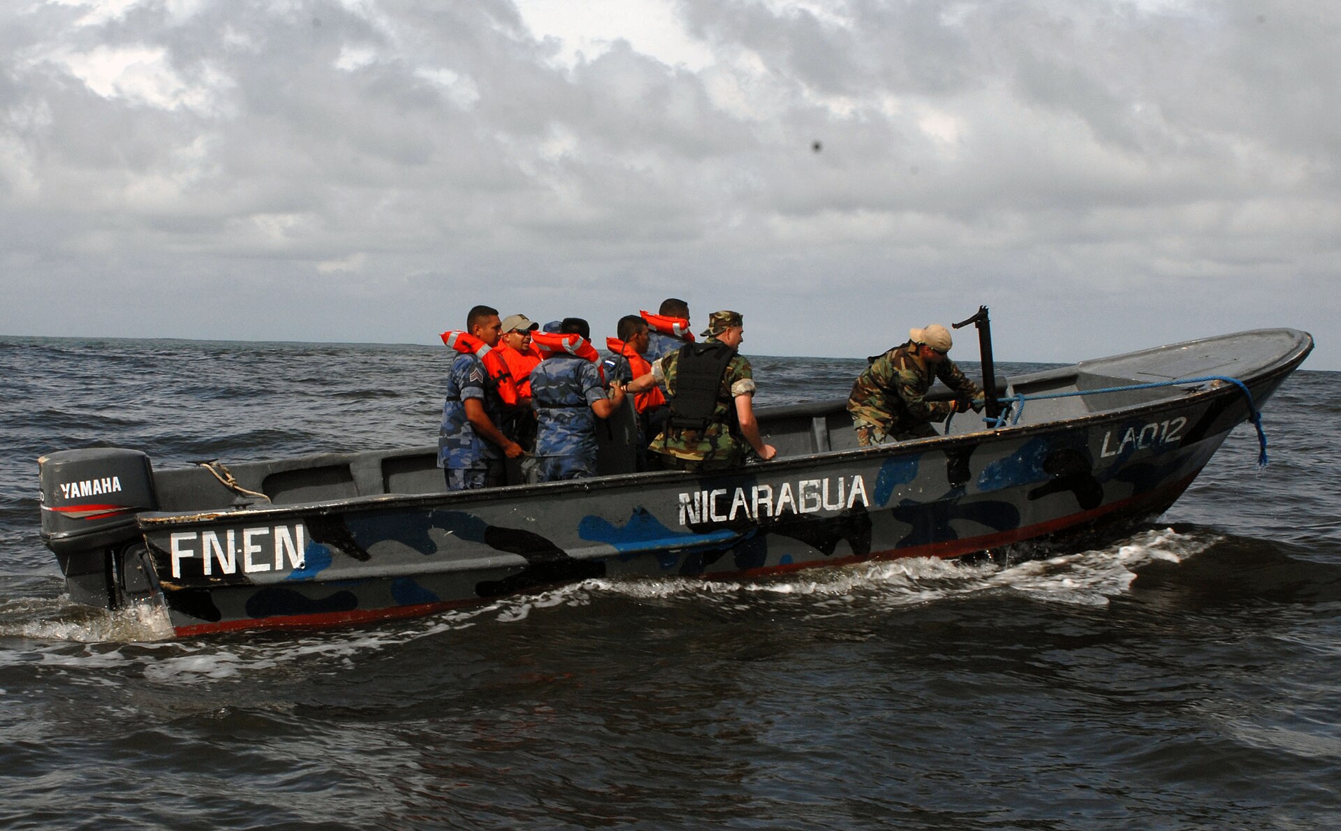 Nicaraguan navy members in life vests aboard a patrol boat marked FNEN Nicaragua on open water under a cloudy sky