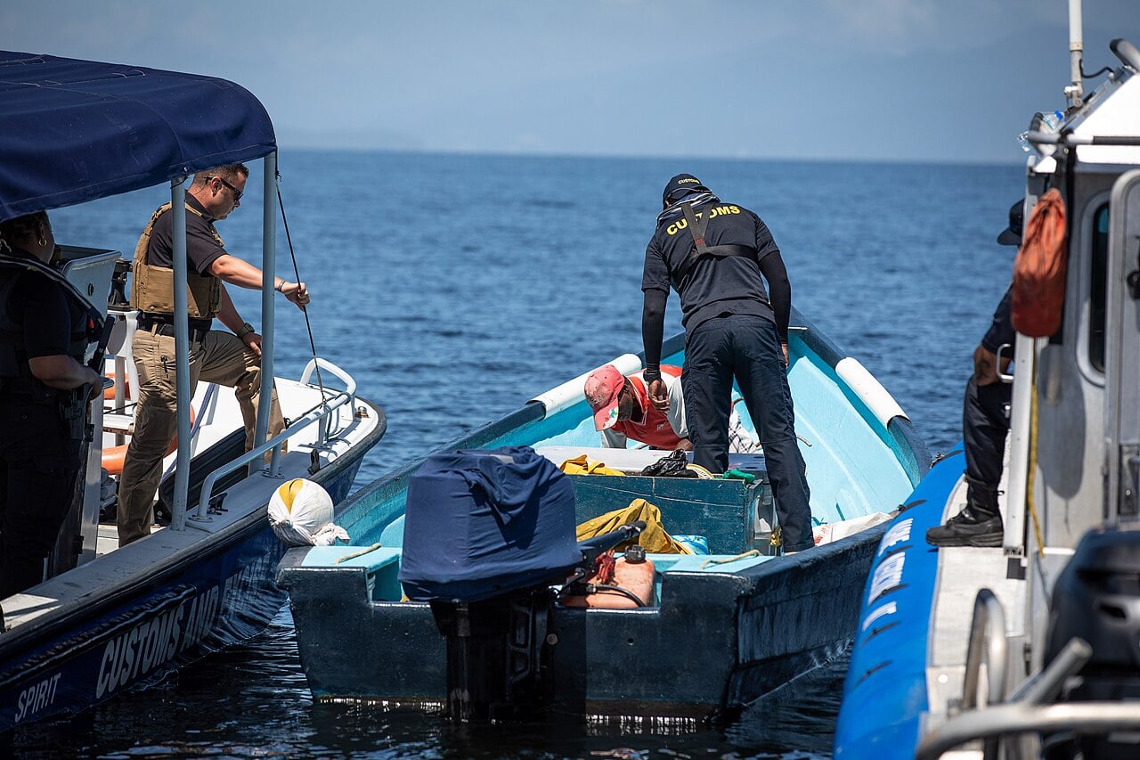 Trinidad and Tobago customs officers inspect a small boat from a patrol vessel at sea off Chaguaramas