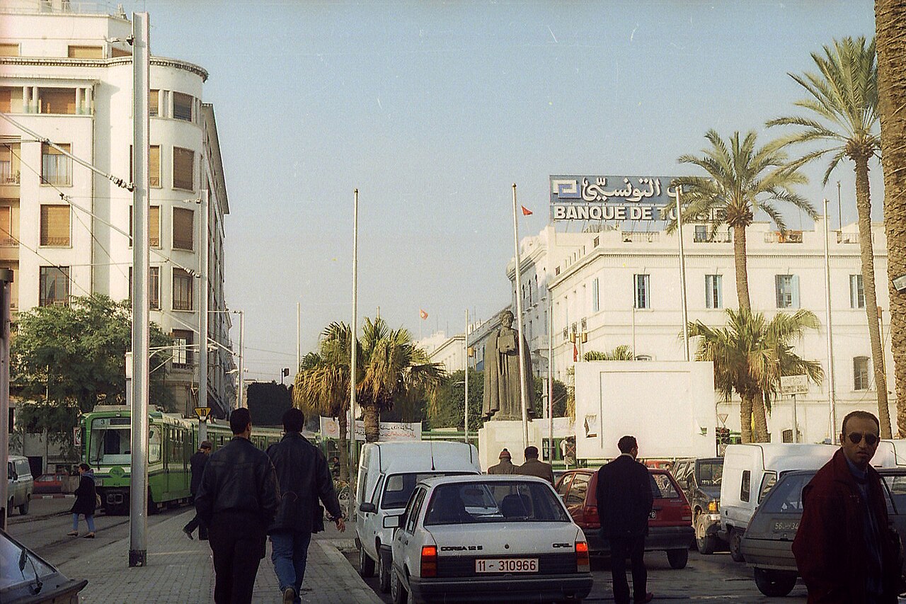 Street scene in downtown Tunis with a tram, a statue and a bank building