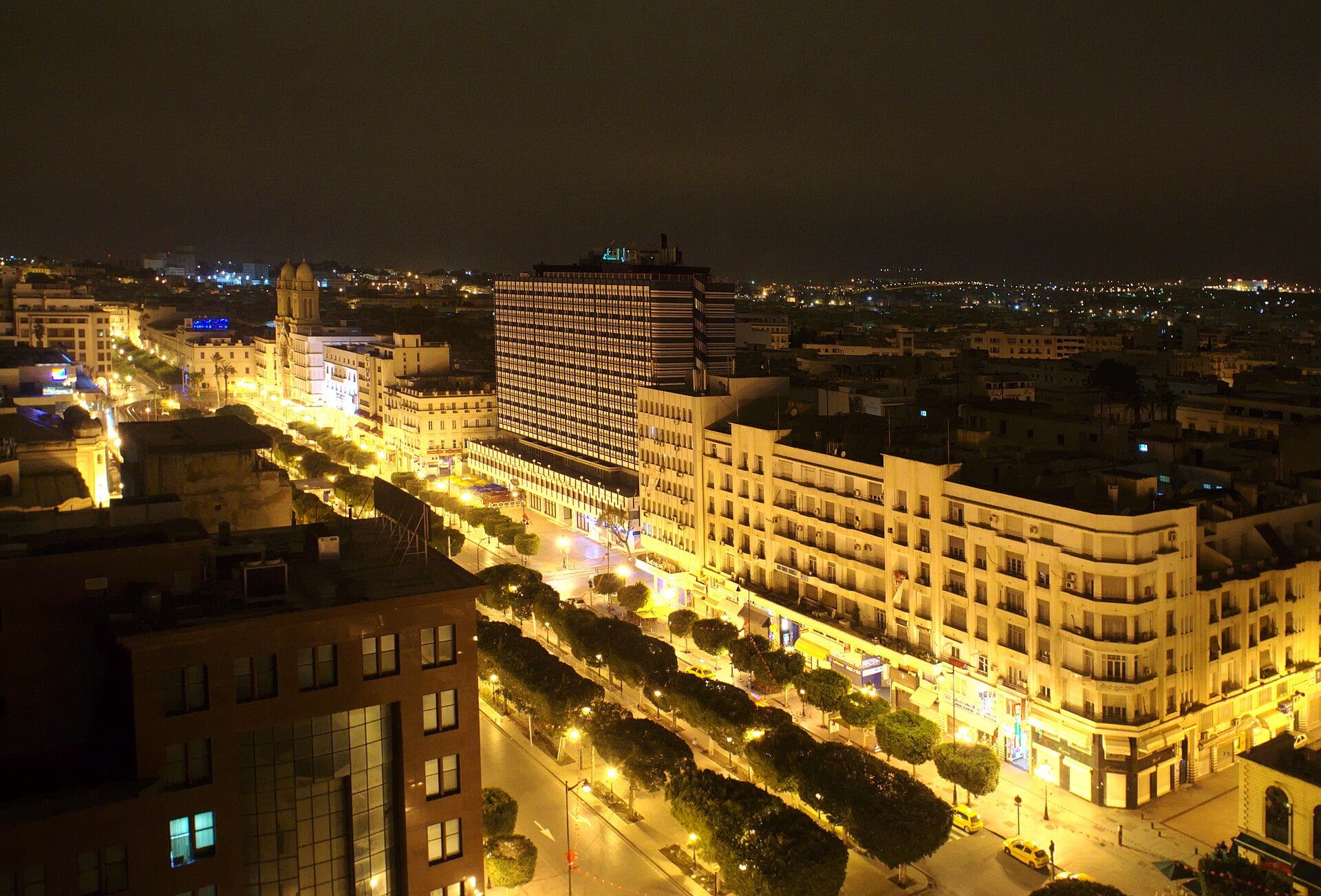 Avenue Habib Bourguiba in Tunis at night, lined with trees and lit buildings