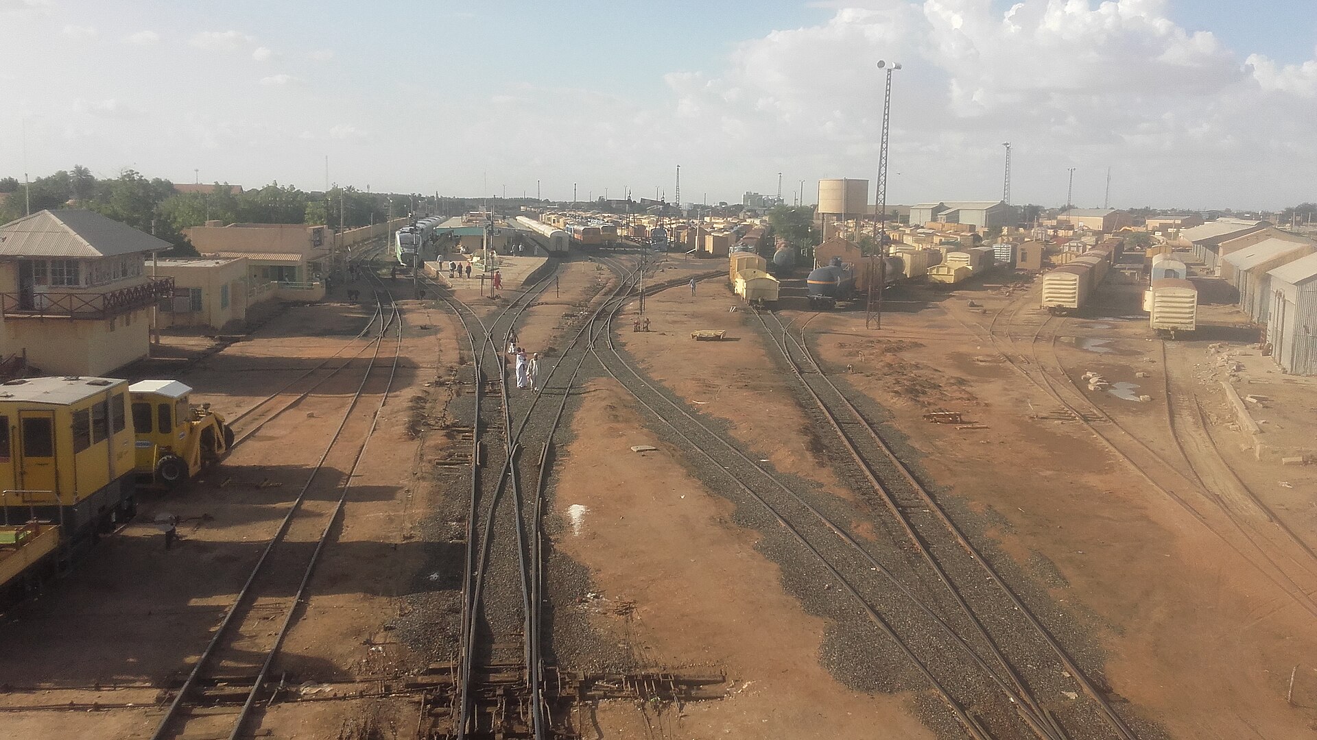 Railway tracks, yellow rail cars and depot buildings at the Atbara railway yard in Sudan