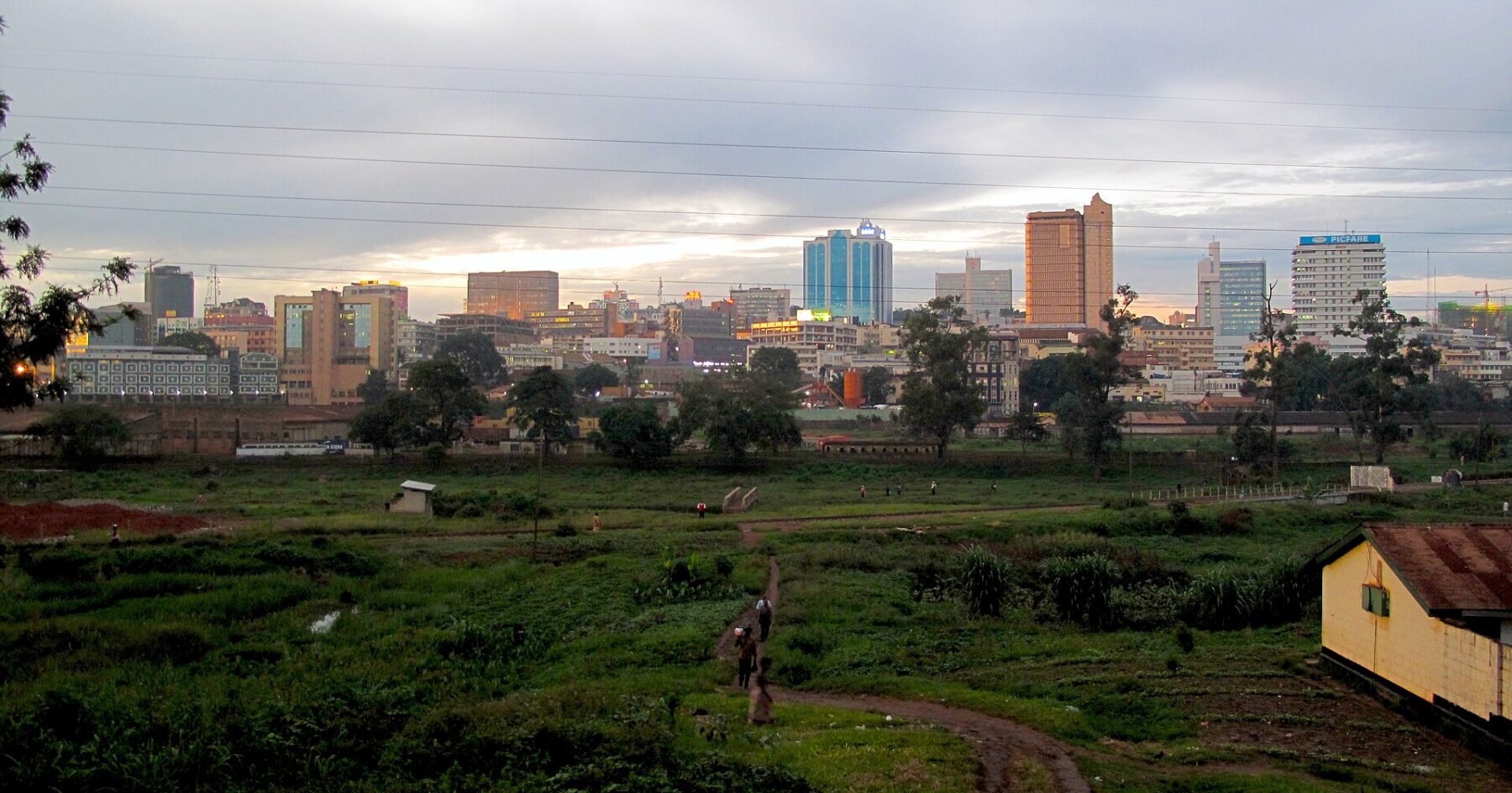 Kampala city centre skyline at dusk, Uganda, with office towers above green open land