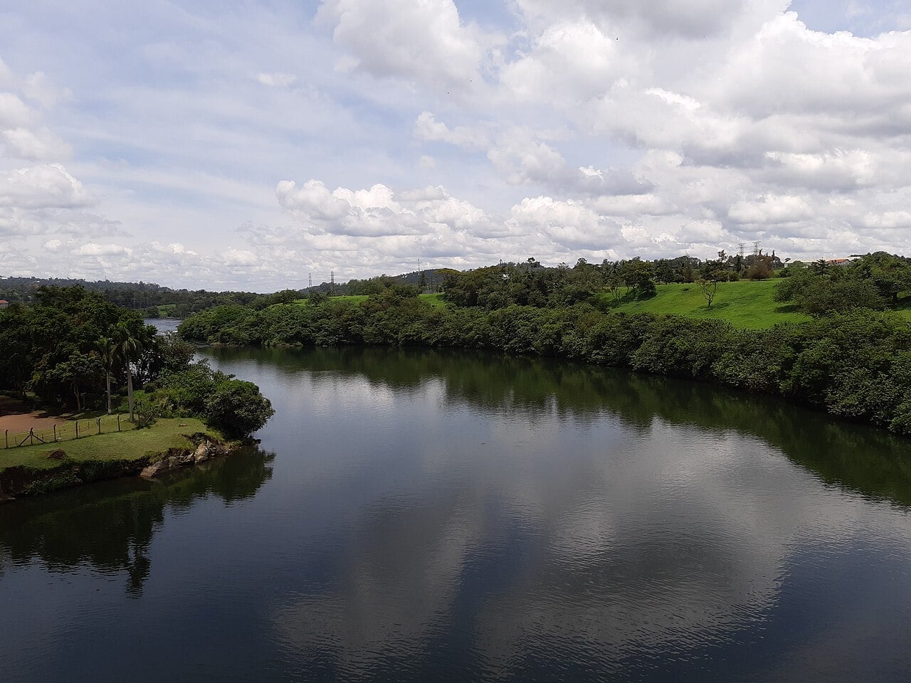 The calm Nile below the Owen Falls dam at Jinja, Uganda, with green banks and power pylons on the hill