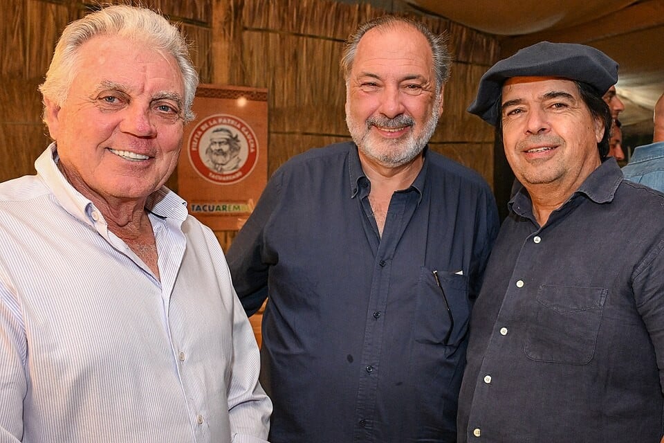 Three men pose at the Fiesta de la Patria Gaucha in Tacuarembó, Uruguay, in March 2026; Jorge Gandini is in the centre