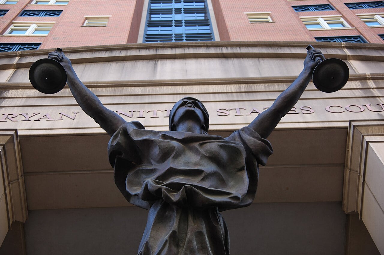 Bronze statue of Lady Justice holding scales at the entrance of the federal courthouse in Alexandria, Virginia
