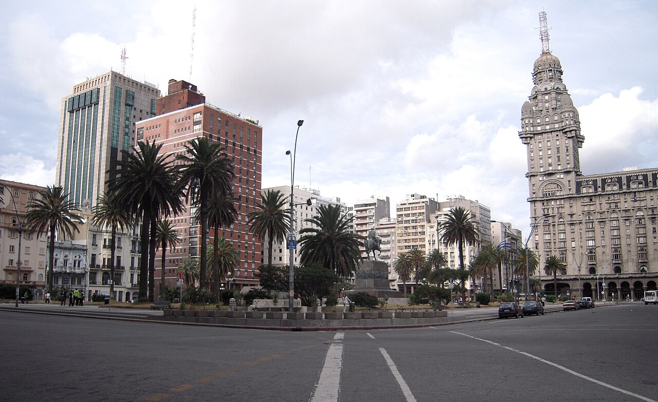 Plaza Independencia in Montevideo with palm trees, an equestrian statue and the tall Palacio Salvo tower on the right