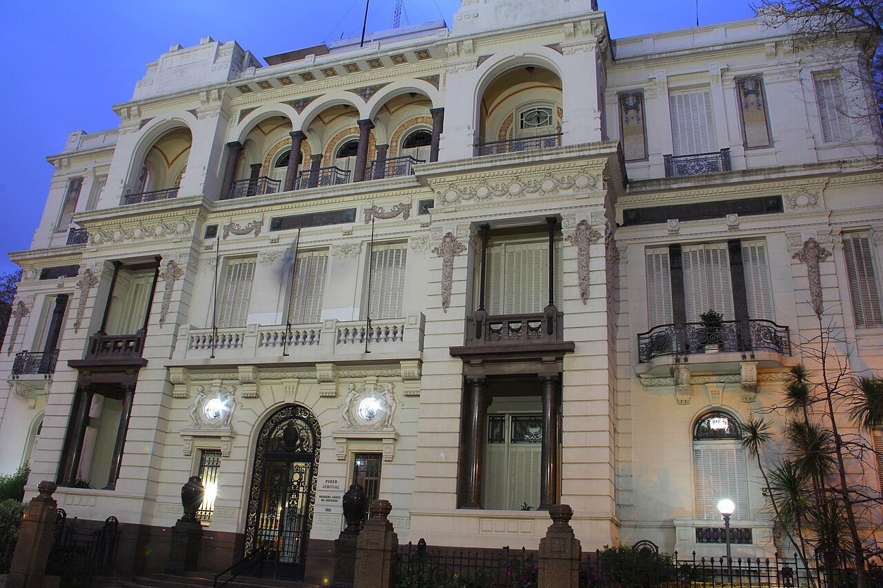 The ornate facade of the Palacio Piria in Montevideo, seat of the Supreme Court of Justice of Uruguay, seen at dusk