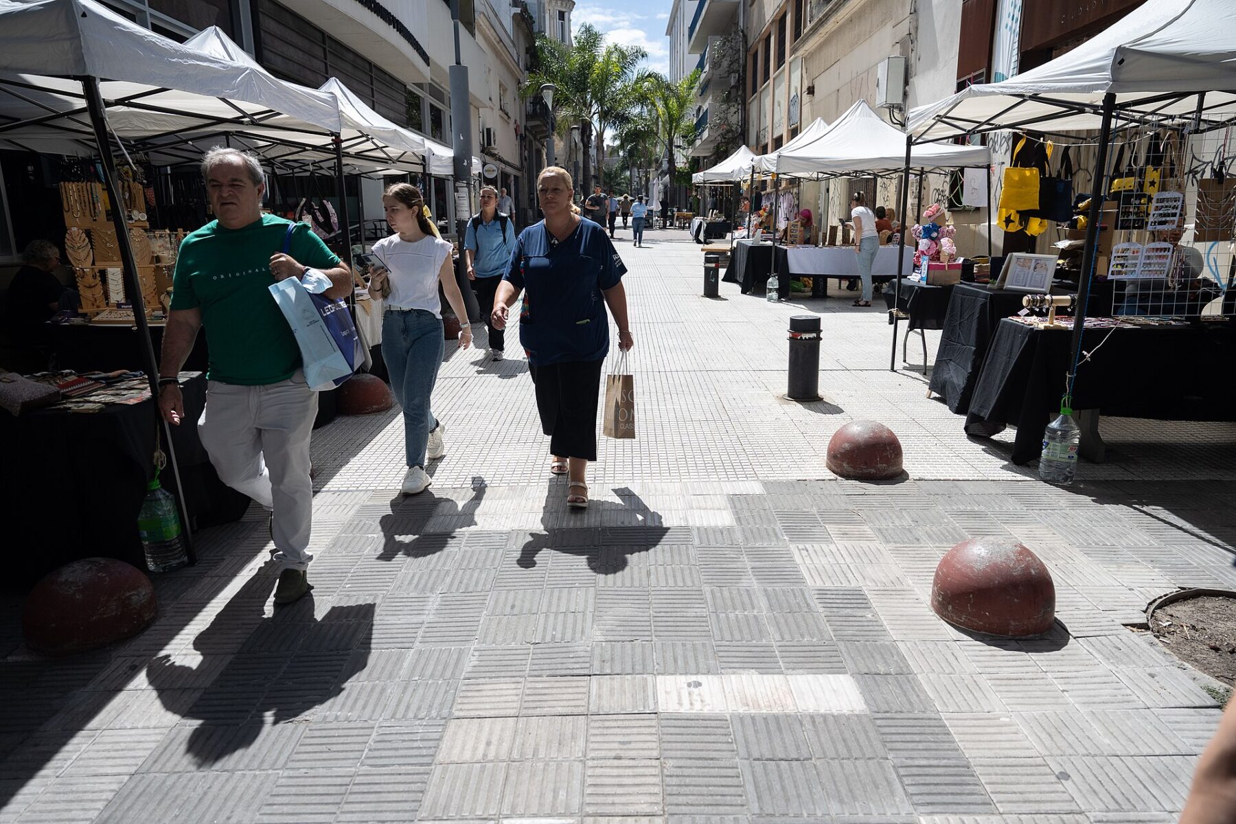 Shoppers walk past market stalls on the Peatonal Sarandi pedestrian street in Montevideo, Uruguay