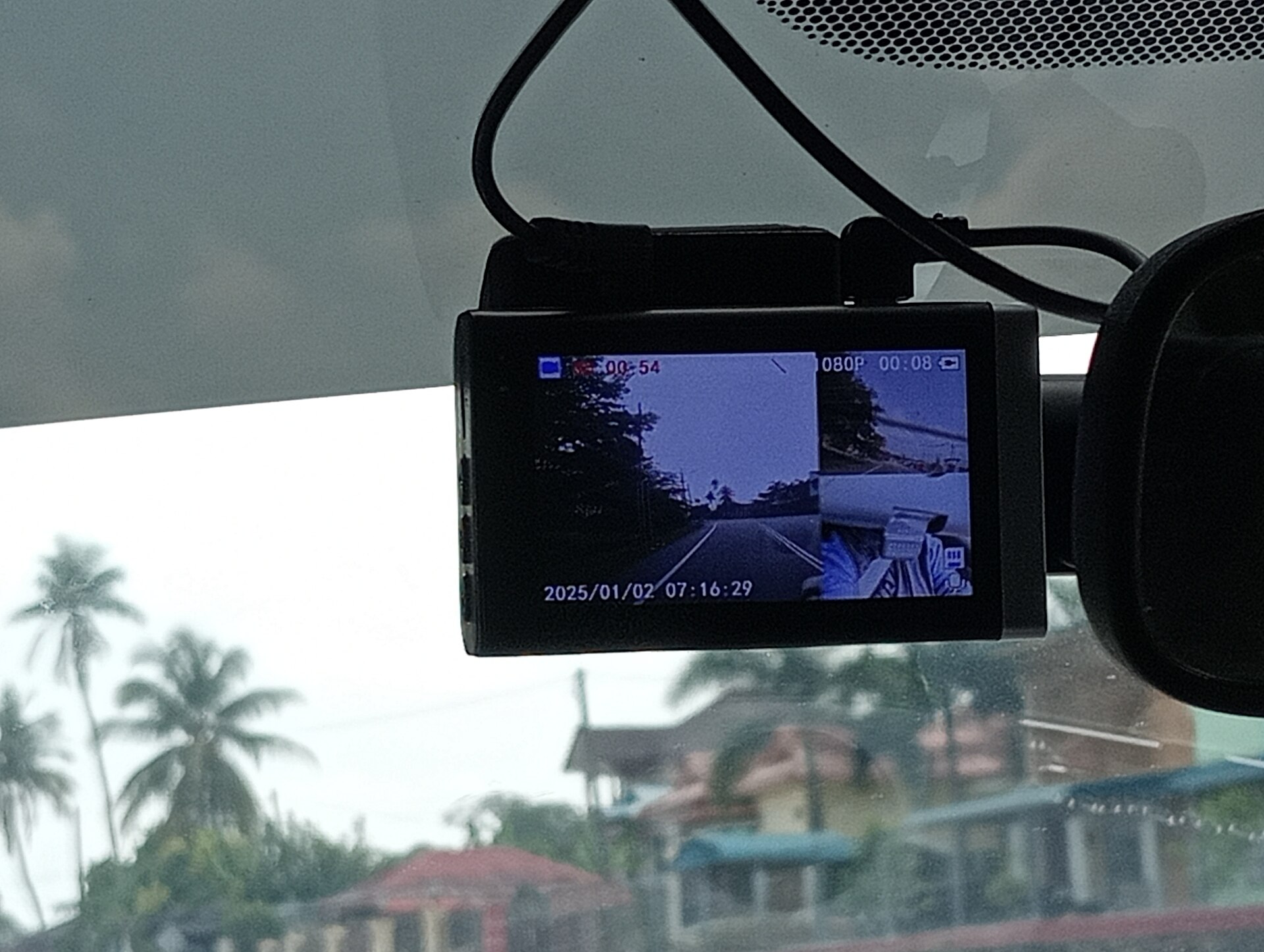 A dashboard camera mounted on a car windshield