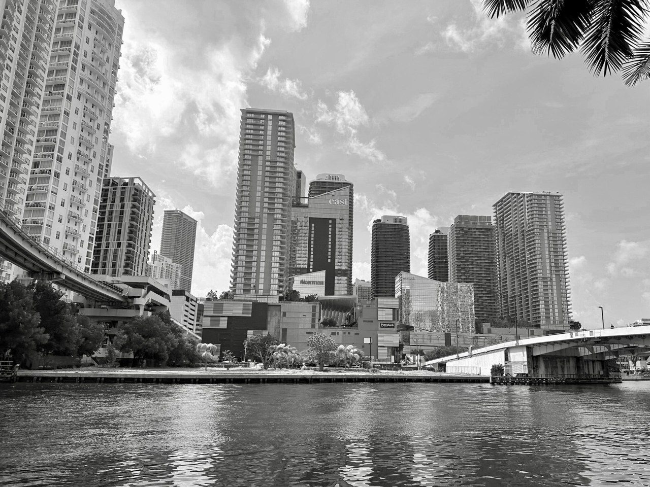 Black-and-white view of the Brickell skyline of Miami, Florida, with high-rise towers beside a river and a bridge