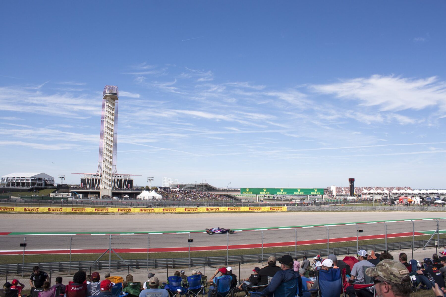 Formula 1 car racing past the observation tower and crowd at Circuit of the Americas, Austin, Texas