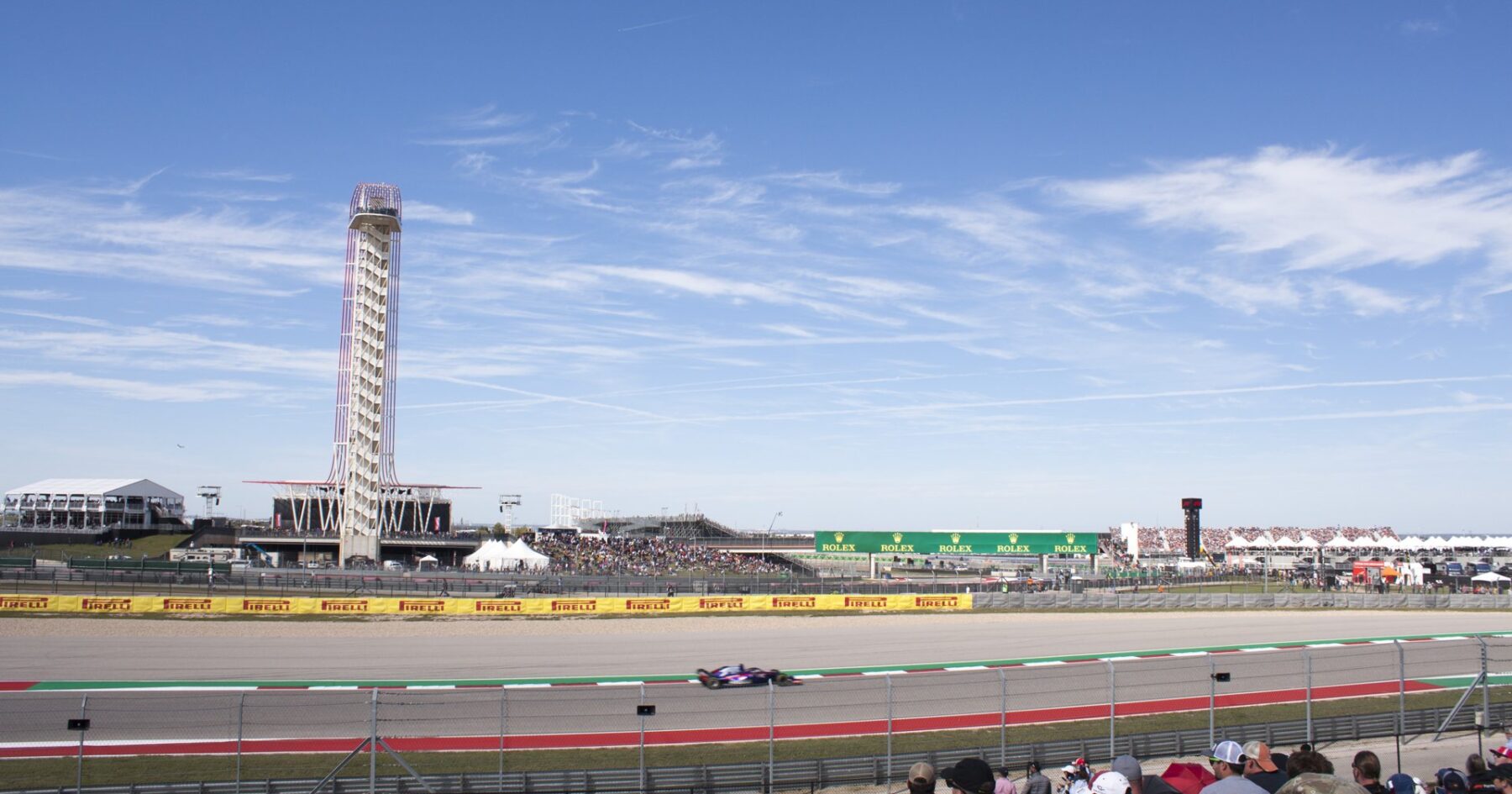 Formula 1 car racing past the observation tower and crowd at Circuit of the Americas, Austin, Texas