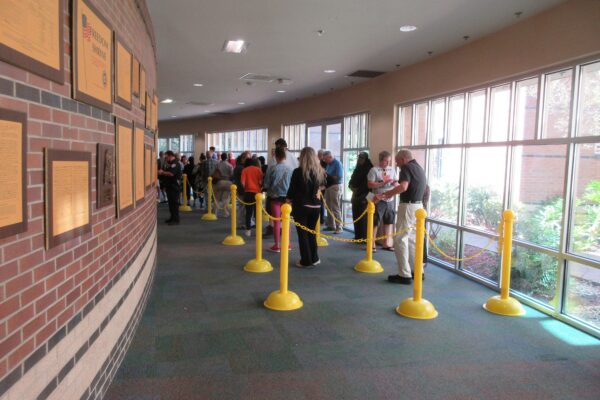 Voters standing in a roped-off line inside a library hallway during early voting in Louisiana