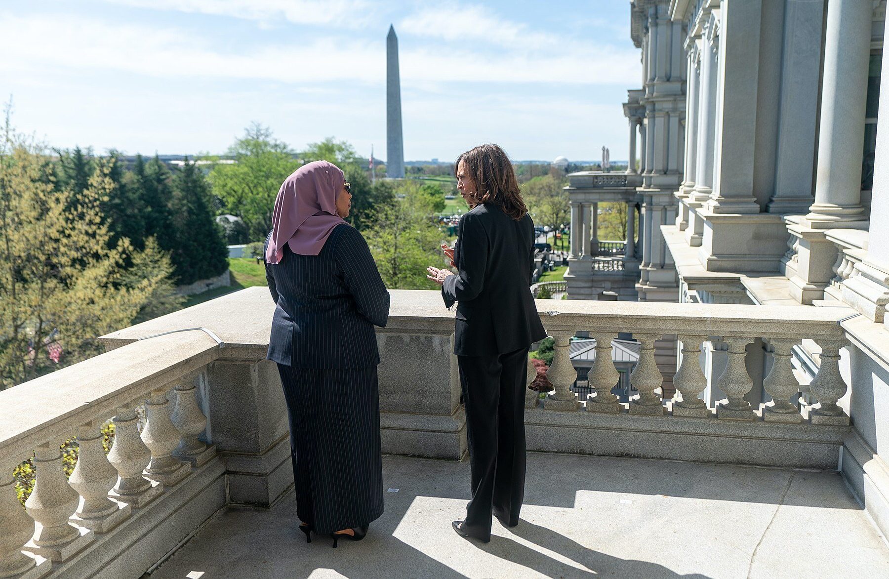 Kamala Harris and Samia Suluhu Hassan talking on a balcony in Washington with the Washington Monument behind them