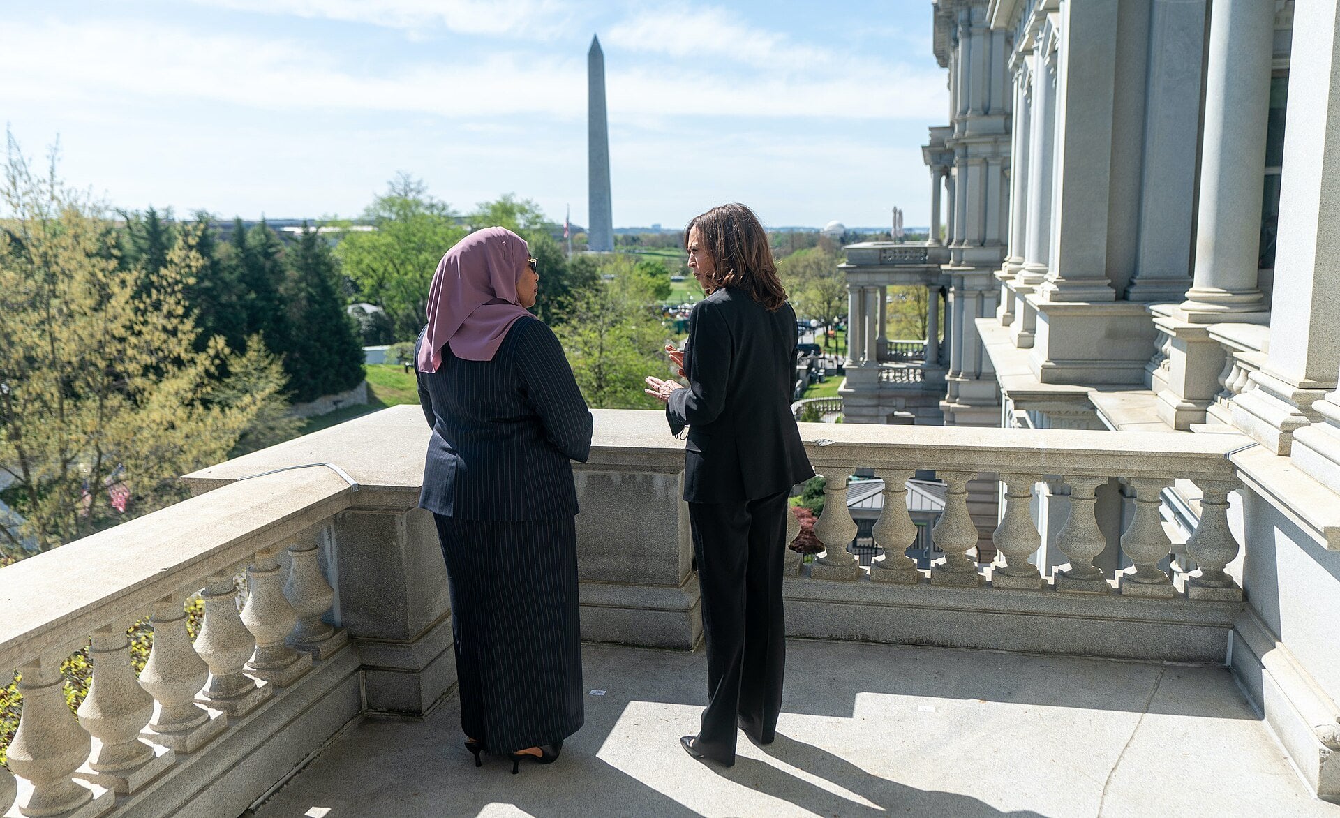 Kamala Harris and Samia Suluhu Hassan talking on a balcony in Washington with the Washington Monument behind them