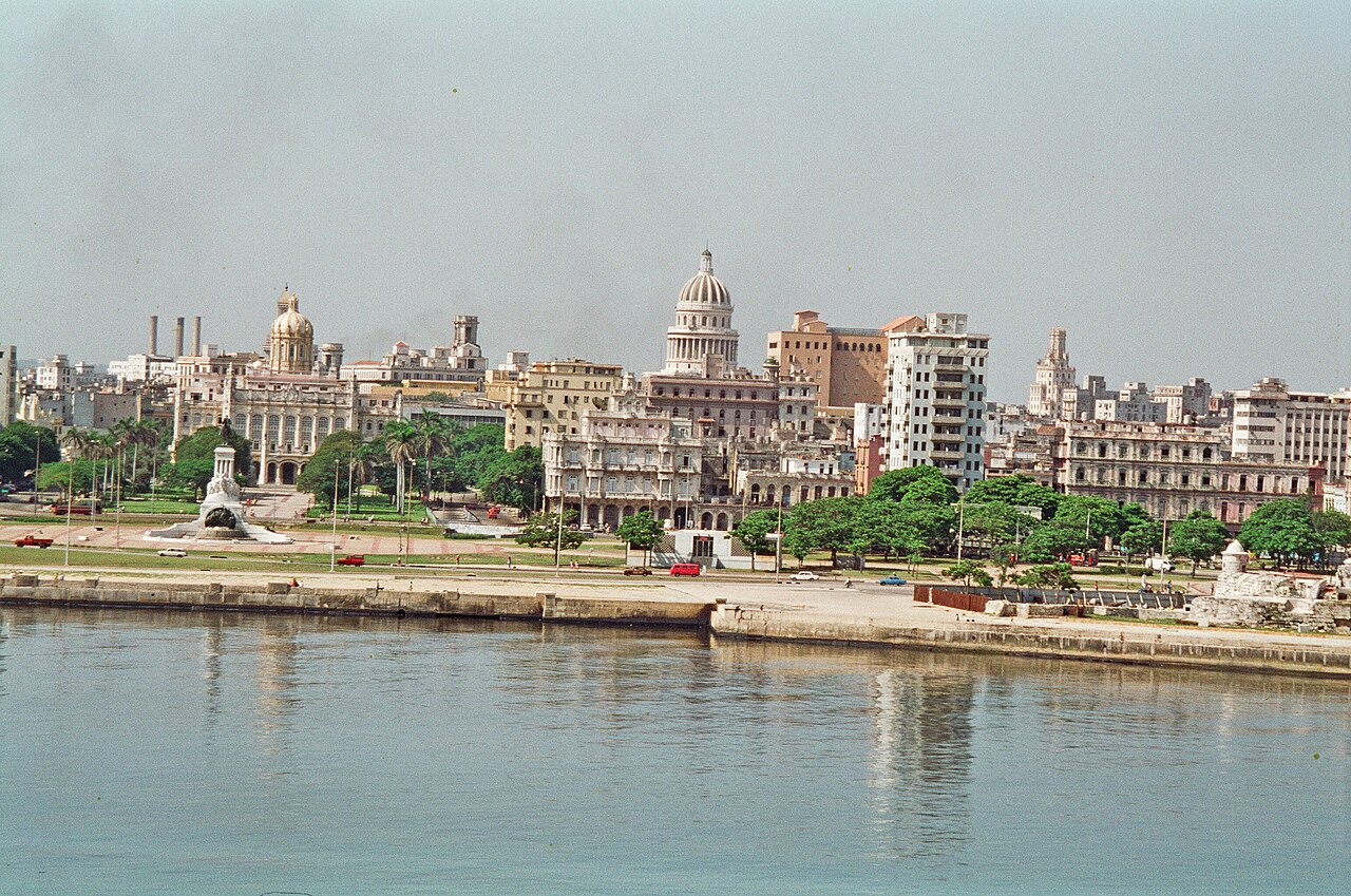 Havana waterfront seen across the harbour, with the Capitolio dome and older buildings behind a seaside promenade