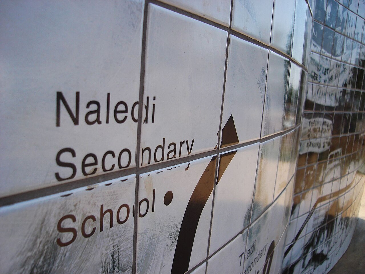 Close-up of a tiled wall bearing the words Naledi Secondary School in Soweto