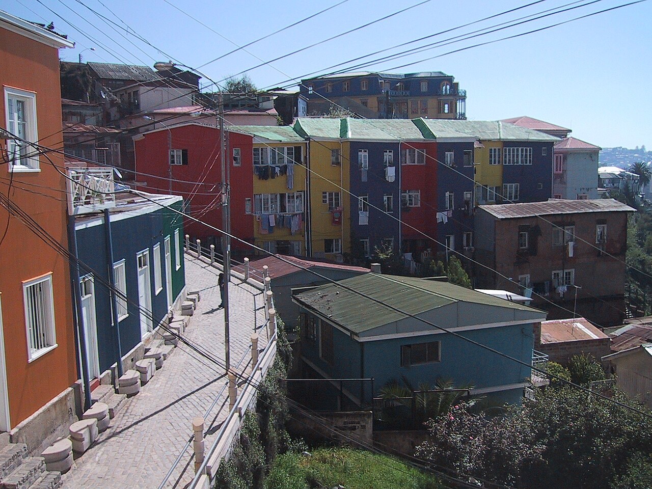 Brightly painted red, yellow, blue and orange houses along a steep cobbled lane in Valparaíso, Chile