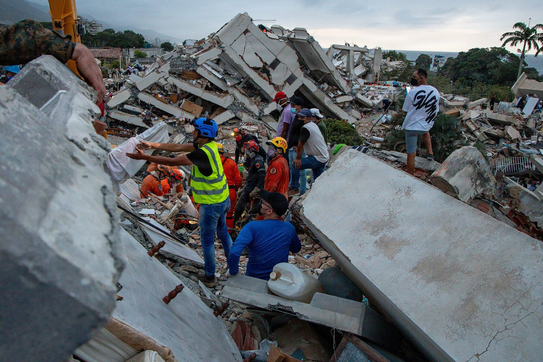 Rescue workers and residents search the rubble of a collapsed building in La Guaira, Venezuela, after the June 2026 earthquakes