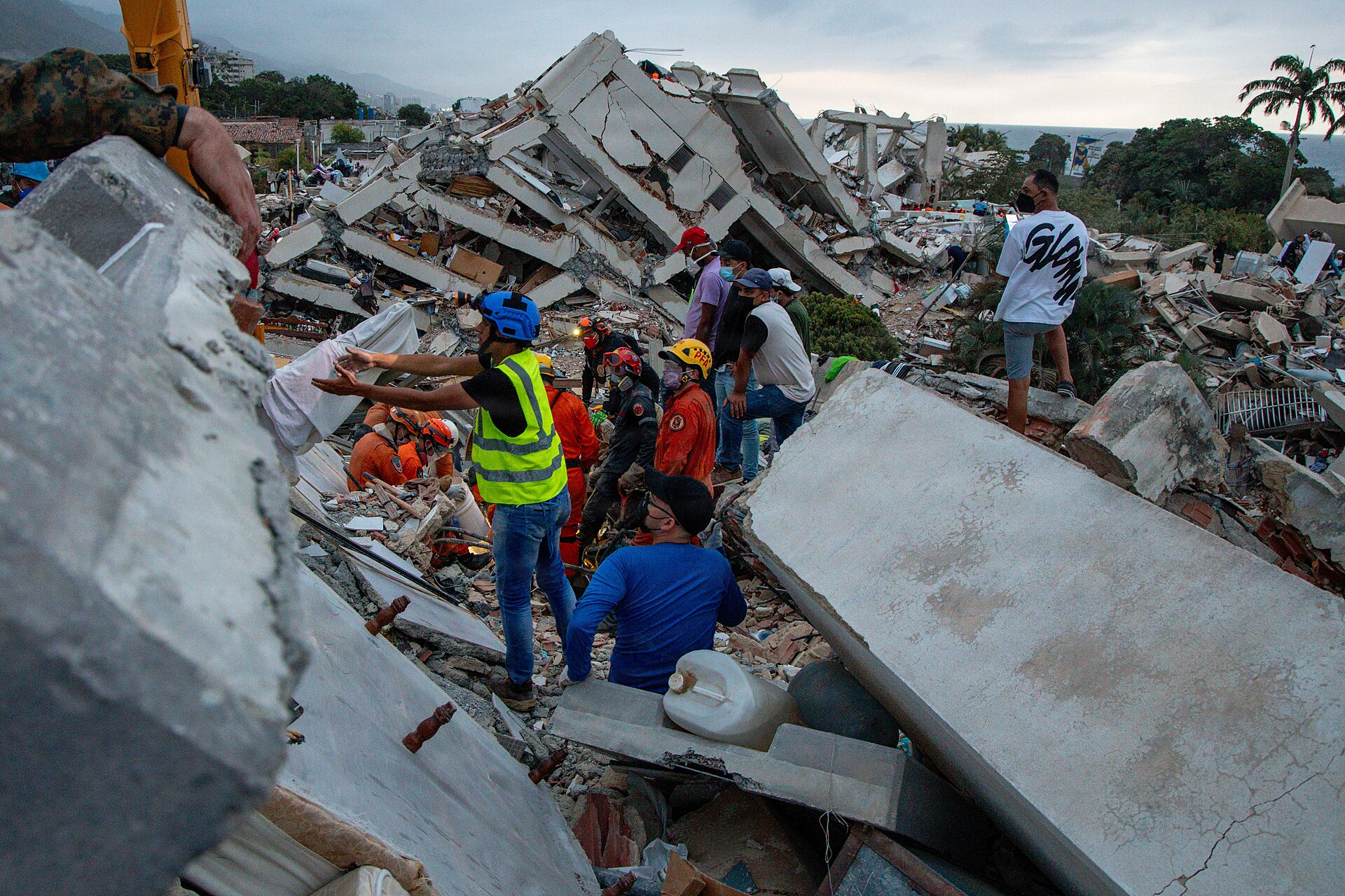 Rescue workers and residents search the rubble of a collapsed building in La Guaira, Venezuela, after the June 2026 earthquakes