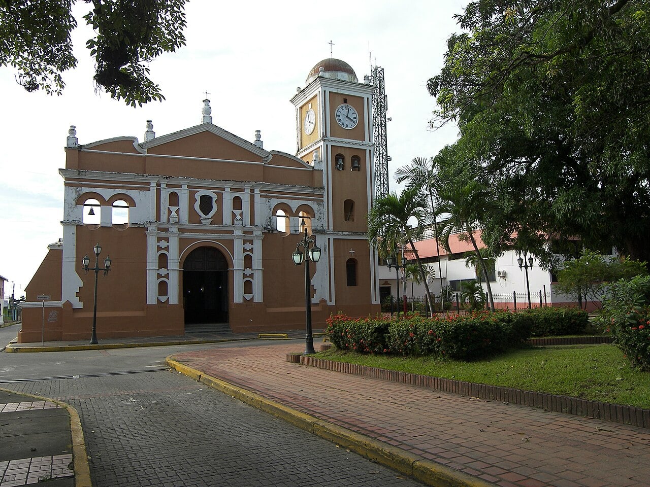 Colonial cathedral of Barinas with a clock tower beside a small plaza with palm trees