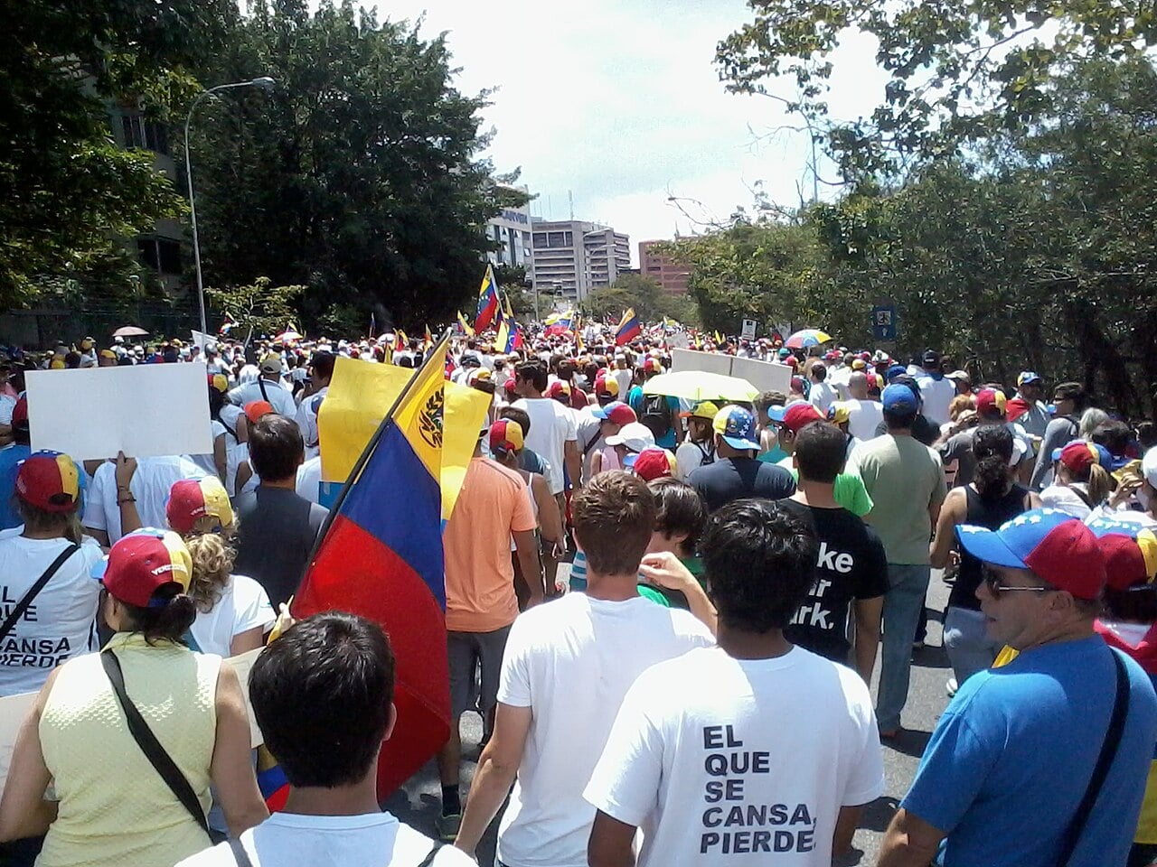 Opposition supporters march with Venezuelan flags along a street in Venezuela