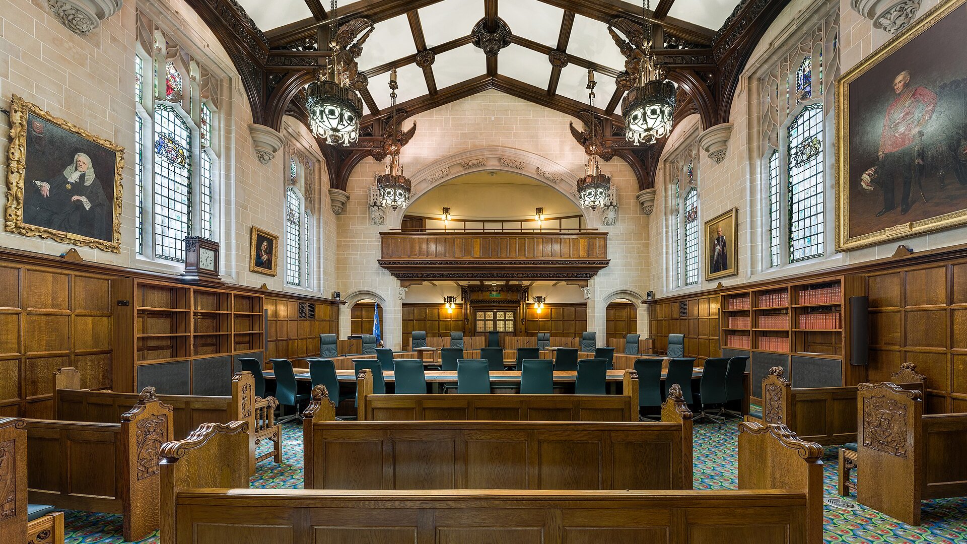 Empty courtroom with wooden benches and judges' chairs in Court 1 of the UK Supreme Court in London