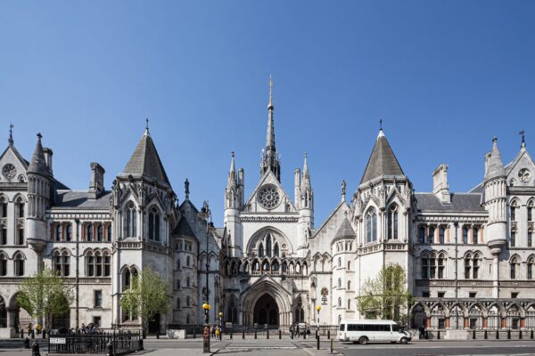 The Gothic front of the Royal Courts of Justice on the Strand in London under a clear blue sky