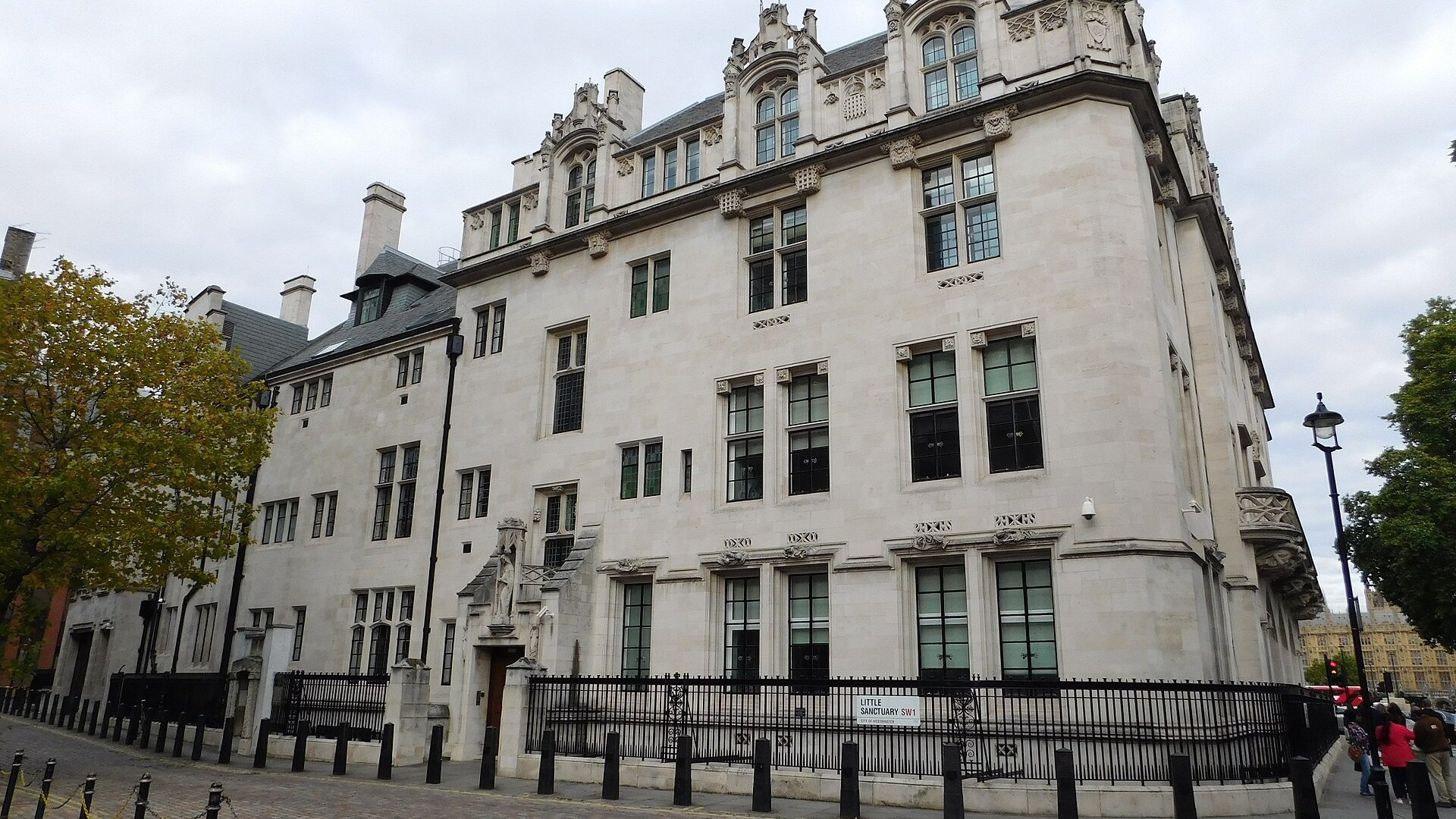 Corner of the UK Supreme Court building in London, a stone Gothic Revival structure beside the Little Sanctuary street sign