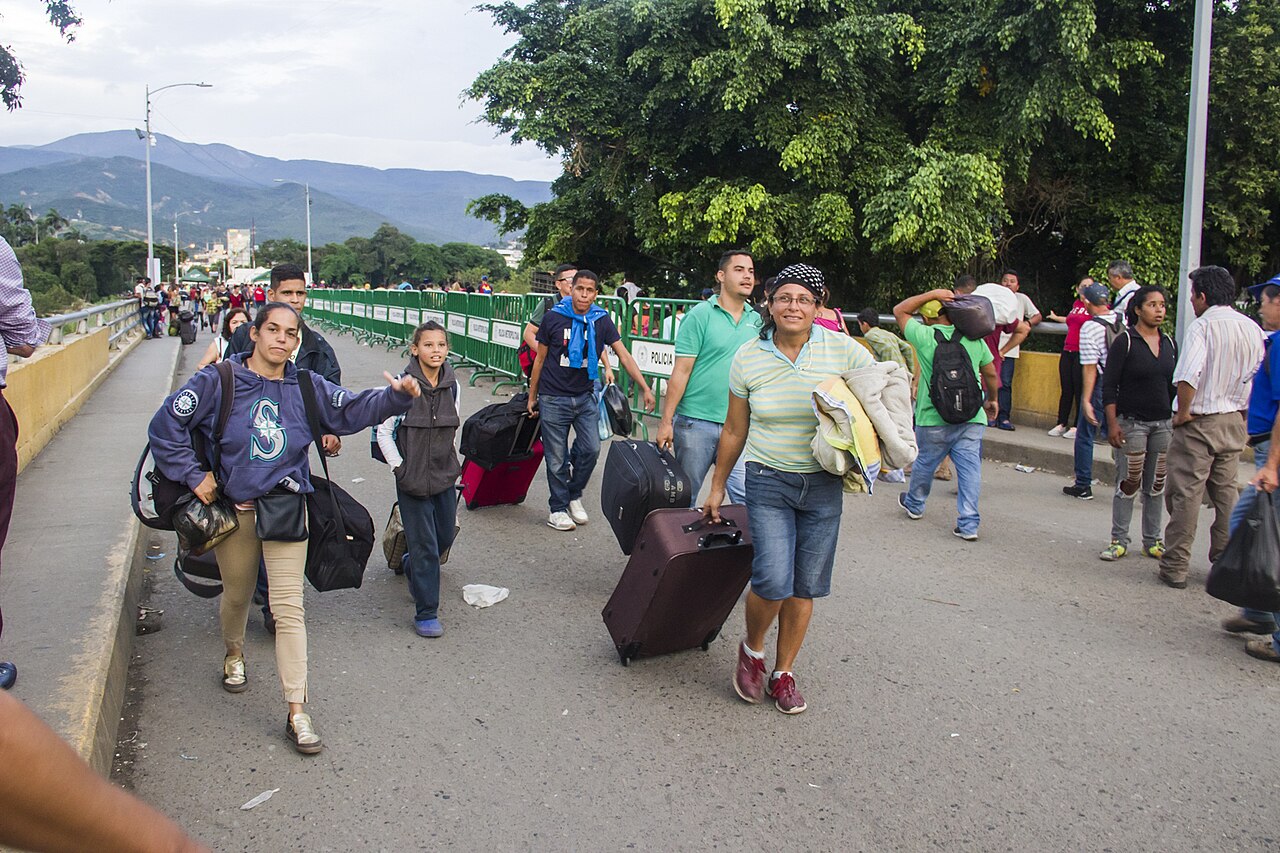 People carrying suitcases and bags walk across the Simón Bolívar International Bridge between Venezuela and Colombia