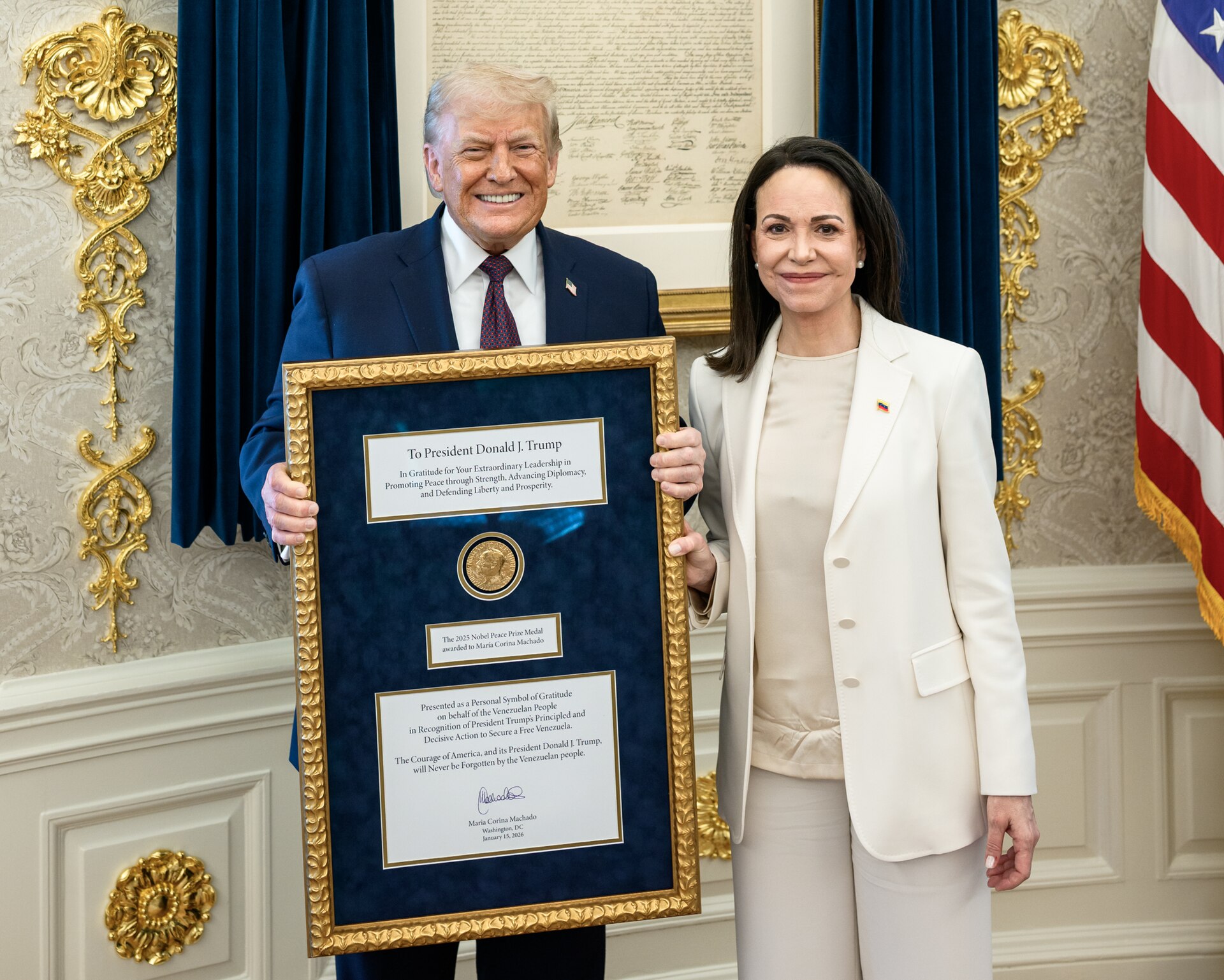 Donald Trump holds a framed Nobel Peace Prize medal beside María Corina Machado in the Oval Office