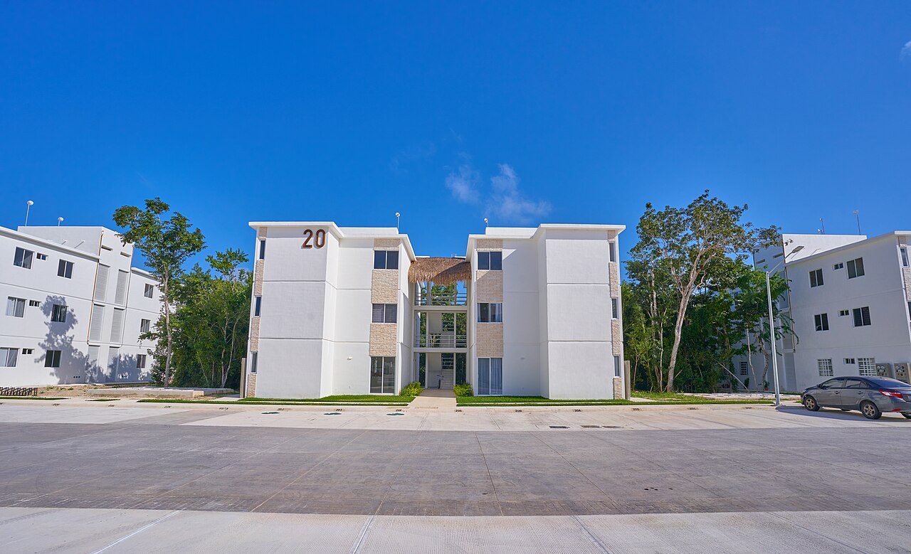 New white three-storey apartment blocks under a blue sky at a Mexican housing development
