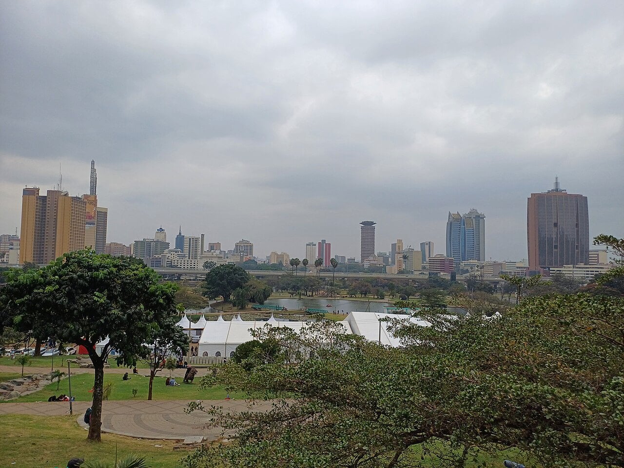Nairobi city centre towers seen across Uhuru Park under a cloudy sky