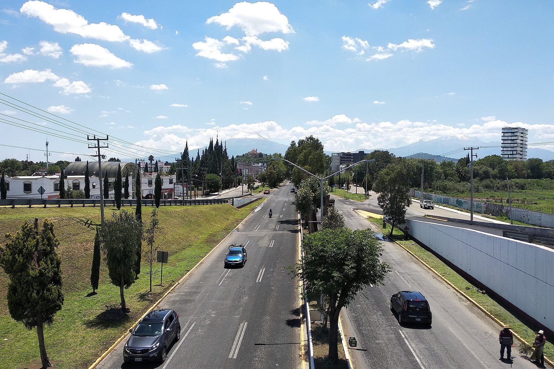 The Recta a Cholula highway between Puebla and Cholula in Puebla state, Mexico, with snow-capped mountains on the horizon