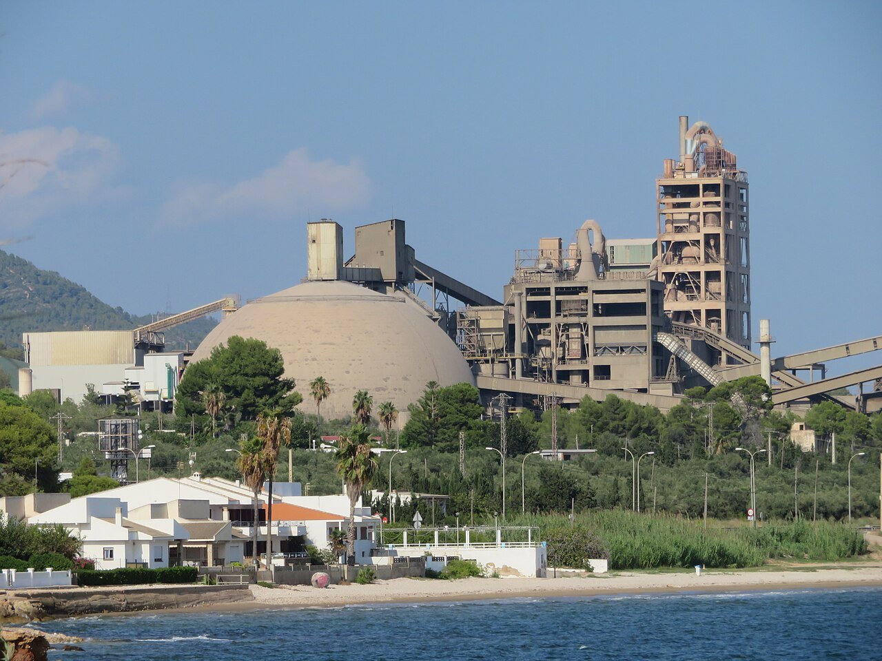 The Cemex cement works at Alcanar in Spain, with a large storage dome and a kiln tower beside the sea