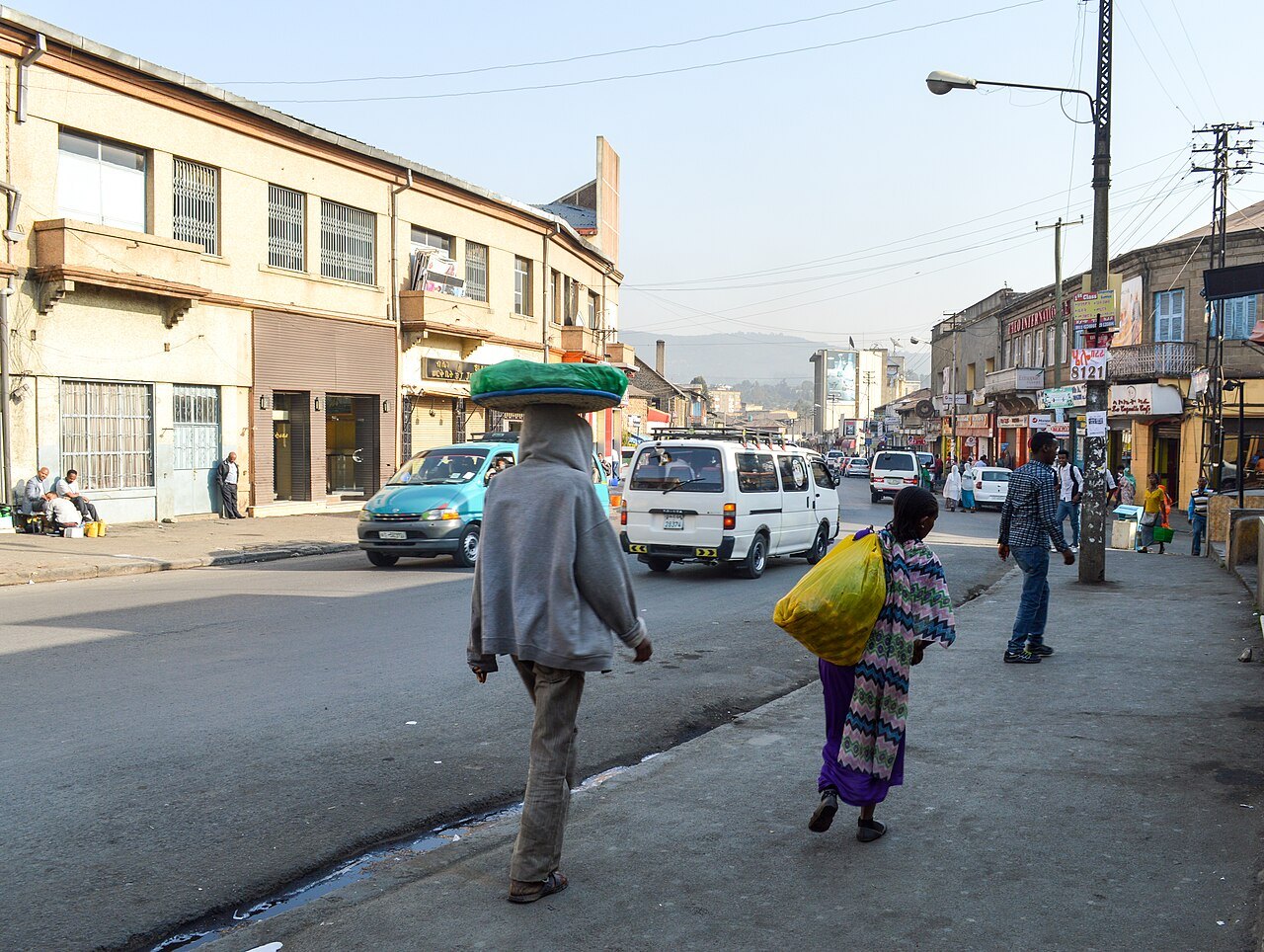 Street in central Addis Ababa with minibuses and pedestrians carrying goods