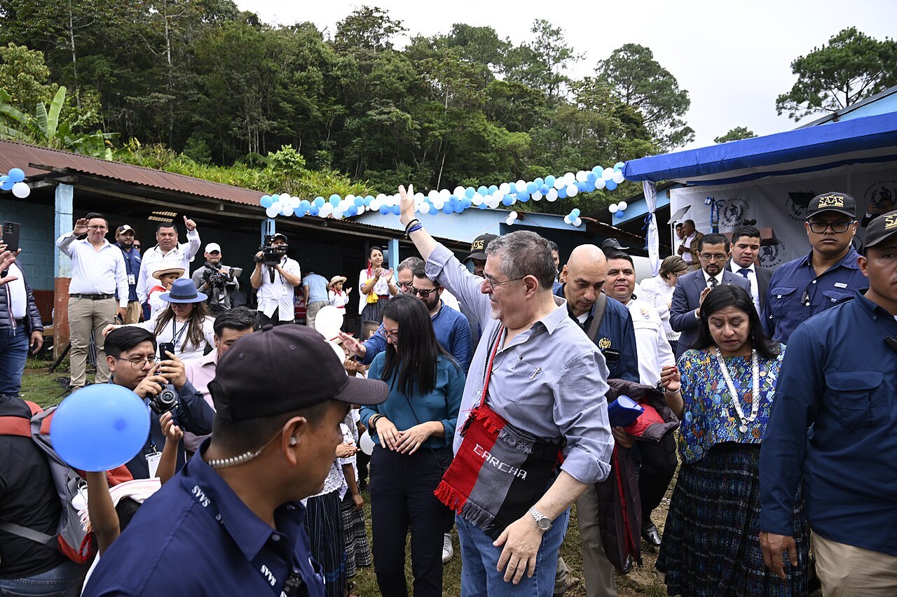President Arévalo, wearing a woven sash, greets a crowd of residents and officials at a rural school opening