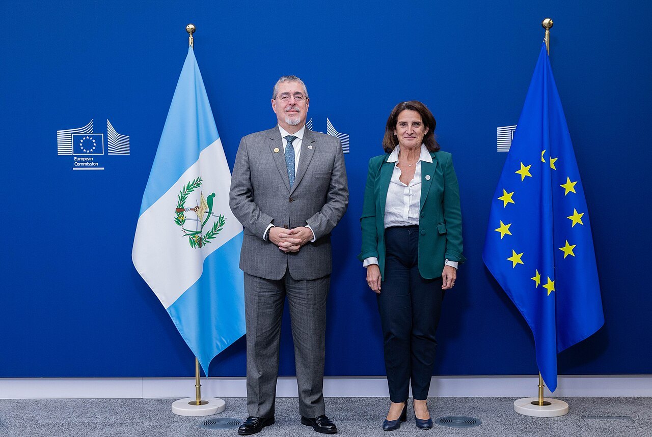 Arévalo stands beside European Commission Executive Vice-President Teresa Ribera between the Guatemalan and EU flags