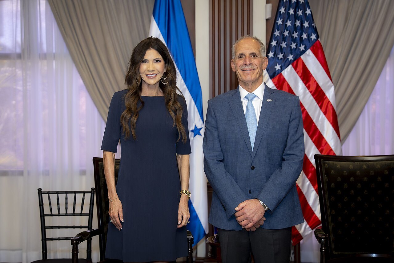 Asfura stands beside US Homeland Security Secretary Kristi Noem in front of Honduran and US flags at the presidential house