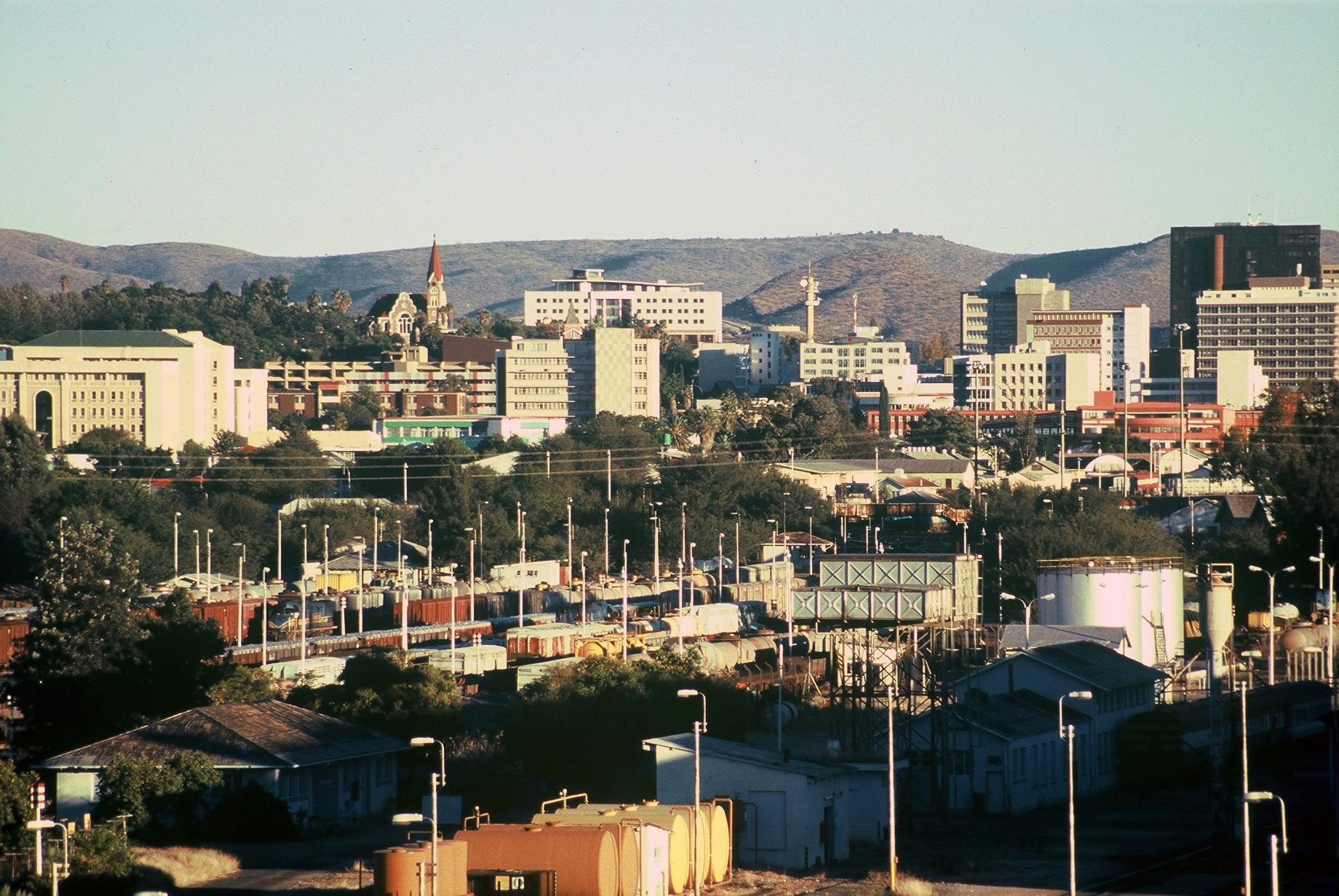 Windhoek city centre with the Christuskirche, office blocks, a rail yard and hills behind