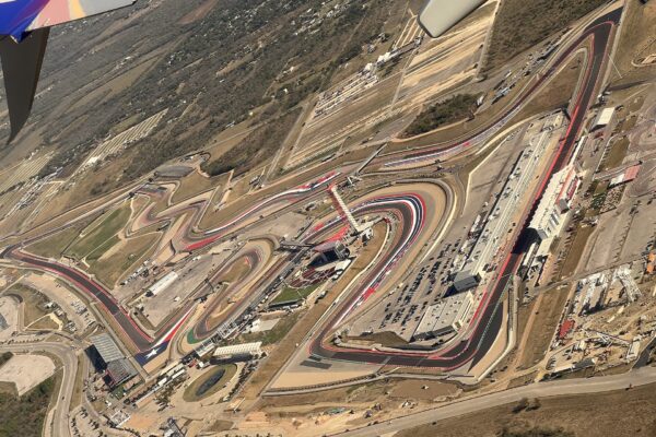 Aerial view of the winding Circuit of the Americas track and its paddock buildings, seen from an airliner window near Austin, Texas