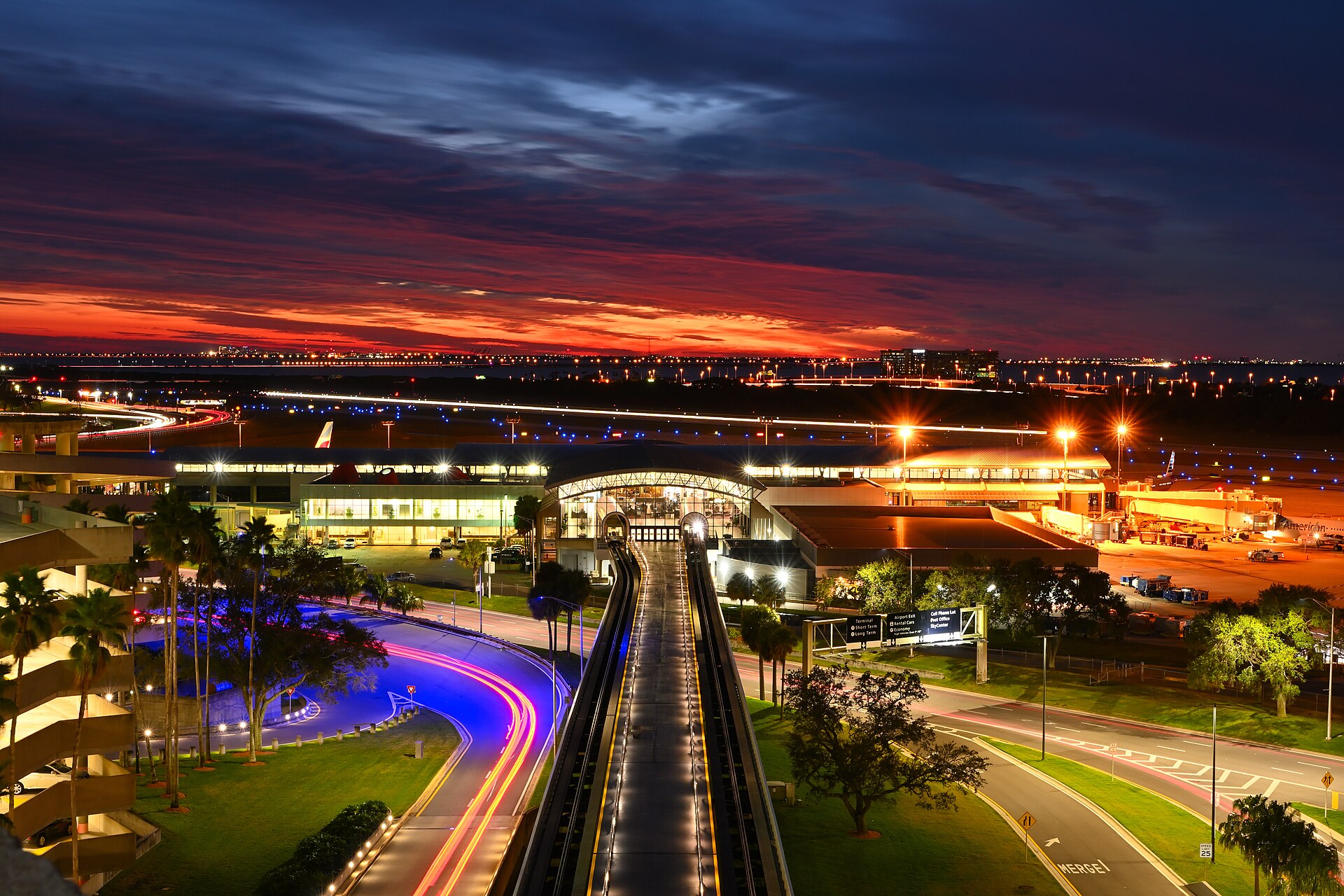 Tampa International Airport terminal and Airside F train line at dusk under a red and purple sky