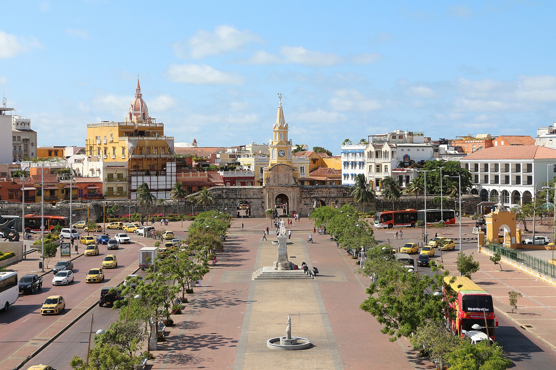 The Plaza de los Coches and the Clock Tower in Cartagena's historic centre, with yellow taxis, trees and a blue sky